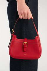 Profile view of model wearing the Oroton Dylan Mini Baguette Crossbody in DARK RUBY and Premium pebble leather for Women .