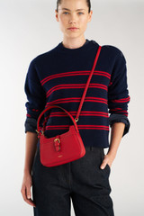 Profile view of model wearing the Oroton Dylan Mini Baguette Crossbody in DARK RUBY and Premium pebble leather for Women .