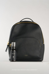 Profile view of model wearing the Oroton Dylan Small Backpack in Black and Pebble leather for Women .