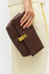 Profile view of model wearing the Oroton Etta Medium Clutch in Bear Brown and Premium smooth leather for Women .
