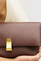 Profile view of model wearing the Oroton Etta Medium Clutch in Bear Brown and Premium smooth leather for Women .