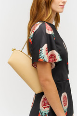 Profile view of model wearing the Oroton Naia Clutch in Biscotti and Premium smooth leather for Women . IP:4