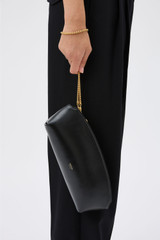 Profile view of model wearing the Oroton Naia Clutch in Black and Premium crackle leather for Women .