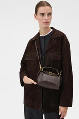 Profile view of model wearing the Oroton Mica Mini Bowler in Dark Chocolate and Premium pebble leather for Women .