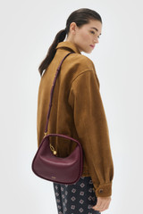 Profile view of model wearing the Oroton Clara Mini Bag in Currant and  for Women .