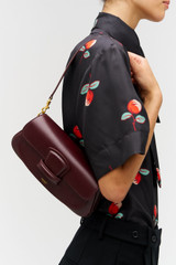 Profile view of model wearing the Oroton Carter Baguette in CURRANT and Premium saffiano leather for Women .