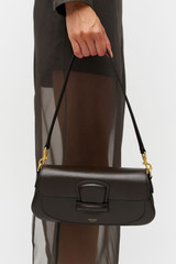 Profile view of model wearing the Oroton Carter Baguette in Dark Chocolate and Premium saffiano leather for Women .