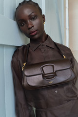 Profile view of model wearing the Oroton Carter Baguette in Dark Chocolate and Premium saffiano leather for Women .