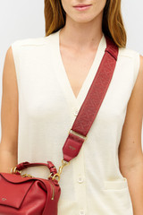 Profile view of model wearing the Oroton Logo Bag Strap in Cherry and Premium leather and webbing material for Women .