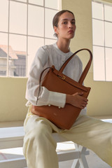 Profile view of model wearing the Oroton Cali Tote in Amber and Premium smooth leather for Women .