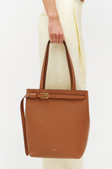 Profile view of model wearing the Oroton Cali Tote in Amber and Premium smooth leather for Women .