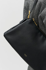 Profile view of model wearing the Oroton Cali Shoulder Bag in Black and Premium smooth leather for Women .