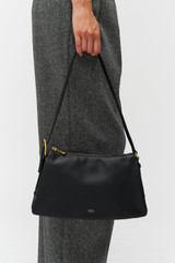 Profile view of model wearing the Oroton Cali Shoulder Bag in Black and Premium smooth leather for Women .