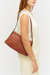 Profile view of model wearing the Oroton Cali Shoulder Bag in Amber and Premium smooth leather for Women .