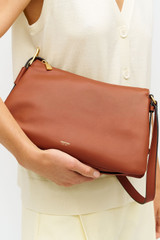 Profile view of model wearing the Oroton Cali Shoulder Bag in Amber and Premium smooth leather for Women .