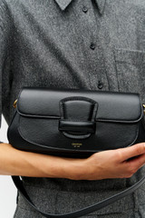 Profile view of model wearing the Oroton Carter Baguette in Black and Premium saffiano leather for Women .