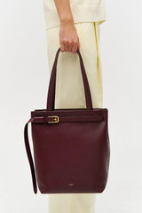 Profile view of model wearing the Oroton Cali Tote in CURRANT and Premium smooth leather for Women .