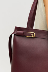 Profile view of model wearing the Oroton Cali Tote in CURRANT and Premium smooth leather for Women .