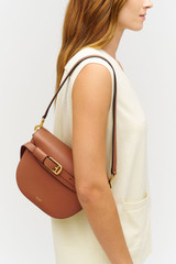 Profile view of model wearing the Oroton Cali Saddle Bag in Amber and Premium smooth leather for Women .