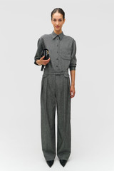 Profile view of model wearing the Oroton Tweed Pleat Pant in CHARCOAL TWEED and Premium blend of 29% polyester, 24% wool, 18% acrylic, 15% silk, 13% viscose, and 1% elastane for Women .