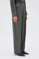 Profile view of model wearing the Oroton Tweed Pleat Pant in CHARCOAL TWEED and Premium blend of 29% polyester, 24% wool, 18% acrylic, 15% silk, 13% viscose, and 1% elastane for Women .