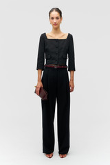 Profile view of model wearing the Oroton Cropped Jacket in Black and Luxurious blend of 97% polyester, 19% wool, and 2% polyurethane for Women .