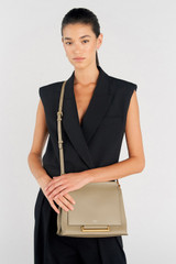 Profile view of model wearing the Oroton Elm Medium Satchel in Mushroom and Premium smooth pebble leather for Women .