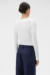 Profile view of model wearing the Oroton Eve Fine Rib Tee in Antique White and 85% cotton and 15% spandex blend fabric for Women .