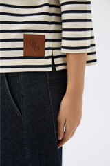 Profile view of model wearing the Oroton Stripe Market Tee in North Sea/Cream and 100% cotton fabric for Women .