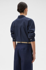 Profile view of model wearing the Oroton Wren Poplin Shirt in North Sea and 100% cotton fabric for Women .