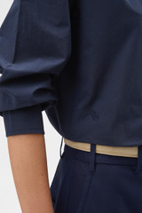 Profile view of model wearing the Oroton Wren Poplin Shirt in North Sea and 100% cotton fabric for Women .