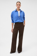 Profile view of model wearing the Oroton Folk Straight Leg Pant in Dark Chocolate and 96% cotton and 4% elastane fabric for Women .