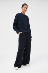Profile view of model wearing the Oroton Flat Front Pant in North Sea and 100% wool fabric for Women .
