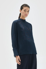 Profile view of model wearing the Oroton Fluid Cutwork Long Sleeve Top in North Sea and 75% acetate and 25% polyester blend fabric for Women .