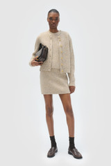 Profile view of model wearing the Oroton Nep Knit Cardi in Oat and 65% merino wool, 30% nylon, and 5% alpaca blend fabric for Women .