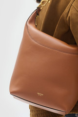 Profile view of model wearing the Oroton Florence Large Hobo in Cognac and Premium smooth leather for Women .