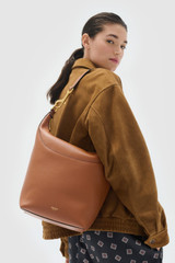 Profile view of model wearing the Oroton Florence Large Hobo in Cognac and Premium smooth leather for Women .