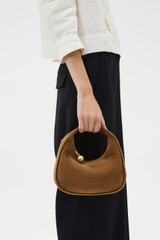 Profile view of model wearing the Oroton Clara Suede Mini Bag in Teak and Premium suede leather for Women .
