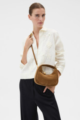 Profile view of model wearing the Oroton Clara Suede Mini Bag in Teak and Premium suede leather for Women .