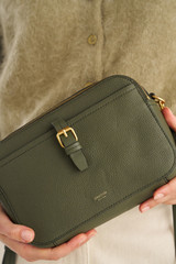 Profile view of model wearing the Oroton Dylan Camera Crossbody in CACTUS and Premium pebble leather for Women .