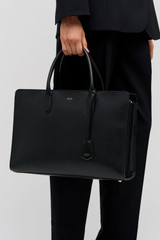 Profile view of model wearing the Oroton Muse 15" Worker Tote in Black and Saffiano leather exterior for Women .