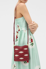 Profile view of model wearing the Oroton Leigh Ric Rac Bucket Bag in Cherry and Premium smooth leather for Women .
