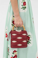 Profile view of model wearing the Oroton Leigh Ric Rac Bucket Bag in Cherry and Premium smooth leather for Women . IP:2