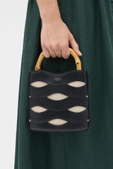 Profile view of model wearing the Oroton Leigh Ric Rac Bucket Bag in Black and Premium smooth leather for Women .