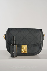 Profile view of model wearing the Oroton Yvonne Signature Medium Saddle Bag in Black and Nylon canvas base cloth material with PVC coating (70% PVC, 30% polyester) for Women .