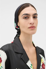 Profile view of model wearing the Oroton Folk Doilie Silk Scarf in Black and 100% silk twill fabric for Women .