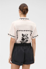 Profile view of model wearing the Oroton Stencil Print Camp Shirt in Soft Peach and 100%  linen fabric for Women .