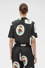 Profile view of model wearing the Oroton Folk Doilie Camp Shirt in Black and 100% silk twill fabric for Women .