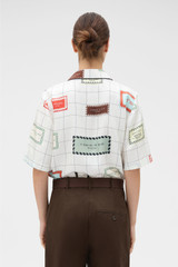 Profile view of model wearing the Oroton Label Print Camp Shirt in Cream and 100% silk twill fabric for Women .