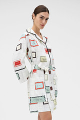 Profile view of model wearing the Oroton Vintage Label Print Tunic Dress in Cream and 100%  linen fabric for Women .